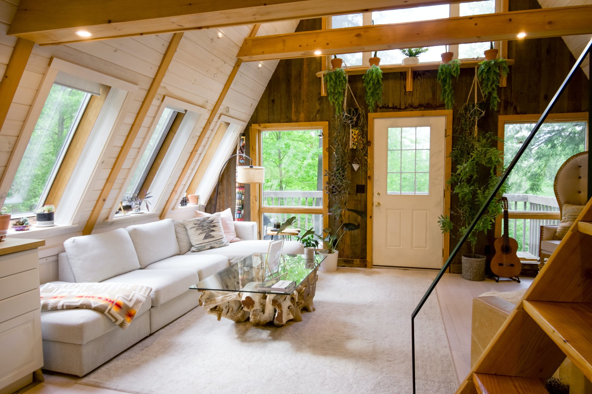 a-frame cabin interior with white couch and green plants